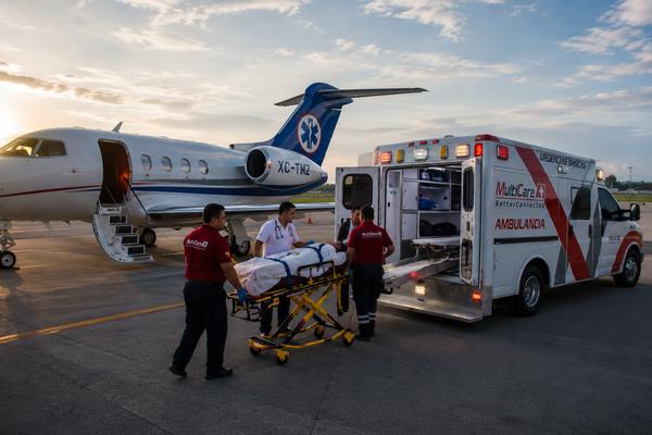 Tripulación de MultiCare A+1 trasladando a un paciente entre la ambulancia y un avión ambulancia en la pista