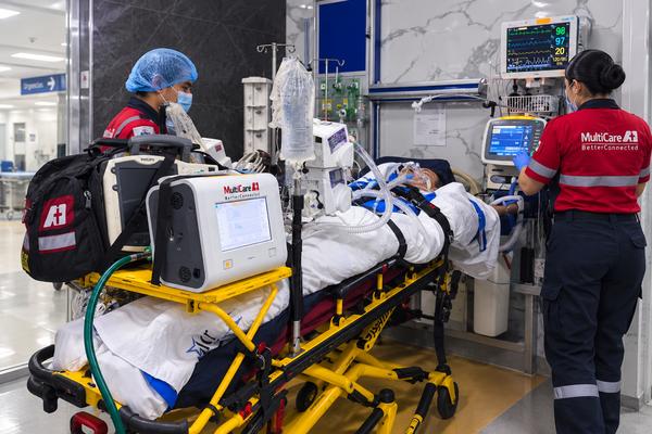 Personal de MultiCare A+1 trasladando a un paciente crítico con ventilador mecánico y monitorización avanzada en unidad de cuidados intensivos móvil